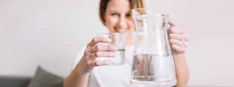 Woman drinking water to cope with phentermine dry mouth