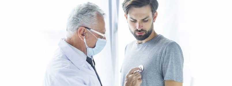 doctor listening to young man's heart