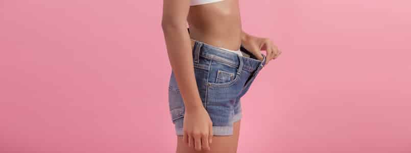 thin woman showing off a too-big waistband on her shorts