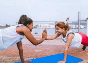 two woman high-fiving while in plank position